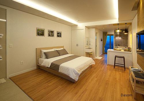 a bedroom with a large bed and a bathroom at Comma&Spa Resort in Seogwipo