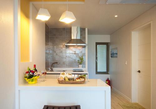 a kitchen with a counter with a basket of food at Comma&Spa Resort in Seogwipo