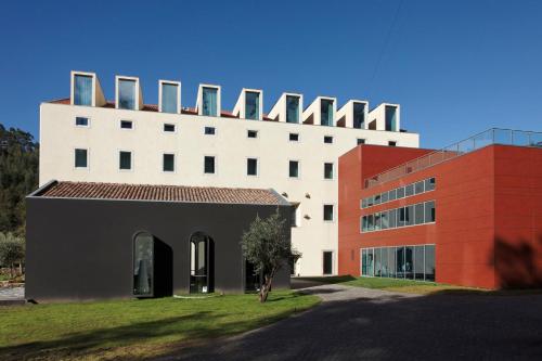 a white building next to a red building at HD | Duecitânia Design Hotel in Penela