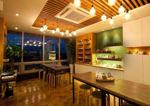 a restaurant with tables and chairs in a room at Comma&Spa Resort in Seogwipo