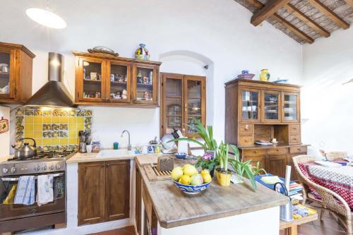 a kitchen with wooden cabinets and a bowl of fruit on a counter at Casa Violet - Goelba in Portoferraio