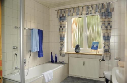 La salle de bains est pourvue d'une baignoire et d'une fenêtre. dans l'établissement Ferienwohnung "Am alten Main", à Kemmern