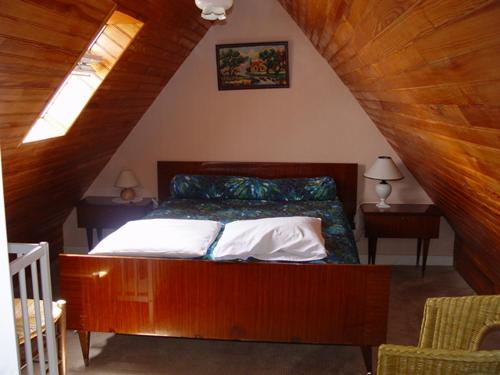 Un dormitorio con una cama con cabecero de madera. en lemoign-locations, en Crozon