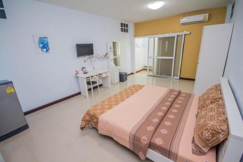 een slaapkamer met een bed en een televisie. bij Ruen Aiyara Apartment in Nakhon Ratchasima