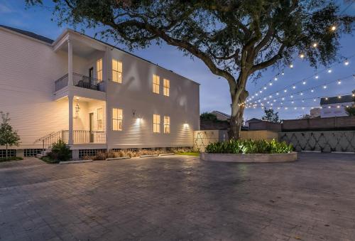 a white building with a tree in front of it at Spacious 2BR in Prime Garden District Location w Pool in New Orleans