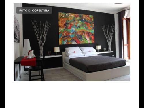 1 dormitorio con 1 cama y una pintura en la pared en Itremoschettieri en Bolonia