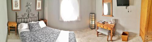 a bedroom with a bed and a desk and a window at Posada Del Camino Real in Torrelaguna