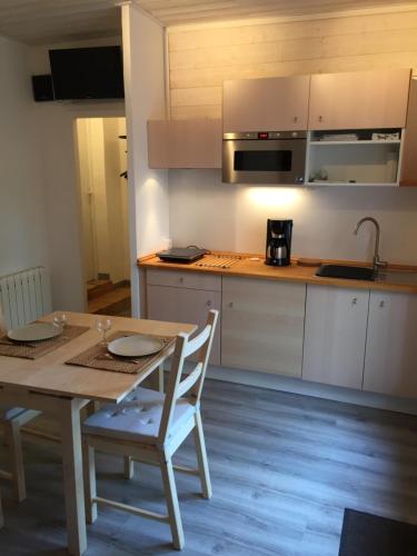 une cuisine avec une table en bois et une table et des chaises dans l'établissement Chez Régine et Serge, à Bandol