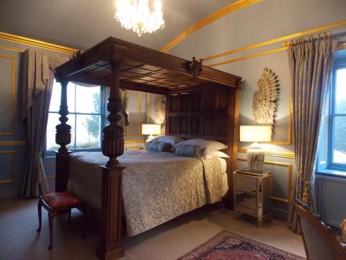 a bedroom with a canopy bed and a chandelier at Rectory Manor in Lavenham