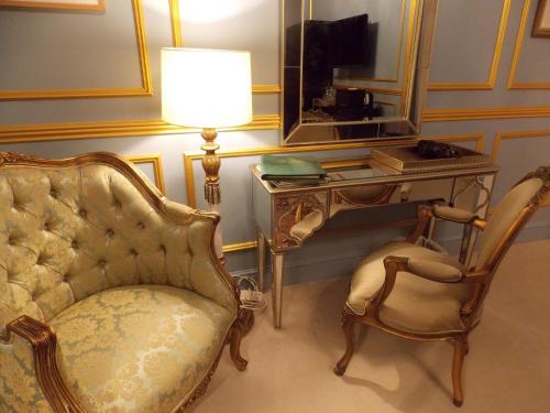 a living room with a chair and a table and a lamp at Rectory Manor in Lavenham