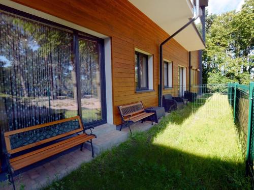 a bench sitting on the side of a house at Dwie Sosny z sauną, Sun & Snow in Ustronie Morskie