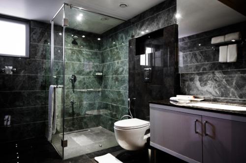 a bathroom with a shower and a toilet and a sink at Kyriad Hotel Gulbarga by OTHPL in Gulbarga