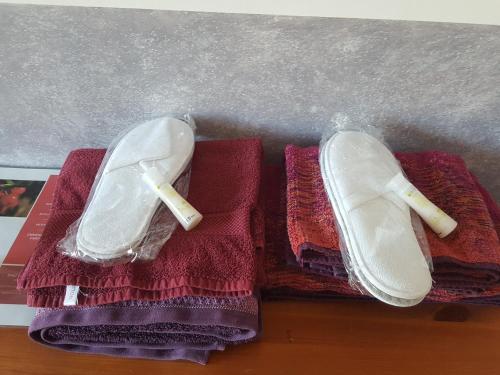 un par de zapatos blancos sentados en toallas púrpuras en chambre chez l'habitant en Céret