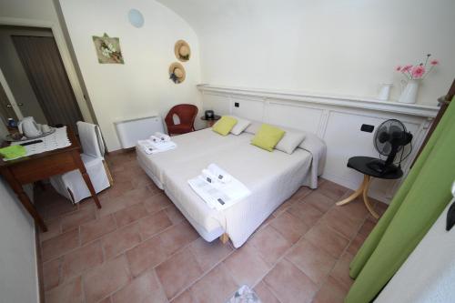 een slaapkamer met een bed, een tafel en een bureau bij Agriturismo Tra Serra E Lago in Roppolo