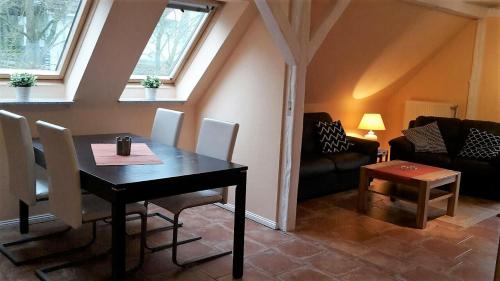 uma sala de estar com uma mesa e cadeiras e um sofá em Haus Wiesenblick em Boltenhagen