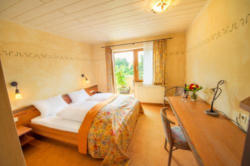 a hotel room with a bed and a desk and a bed sidx sidx at Landgasthof Schwarz in Windsbach