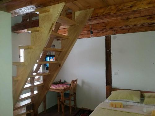 a room with a bed and a wooden staircase at Seoski turizam Ziličina Rogatica in Rogatica