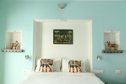 a bedroom with a white bed with two pillows at Little Garden Guest House in Udaipur