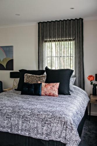 a bedroom with a bed with pillows and a window at Northfield Boutique Apartments in Woodend