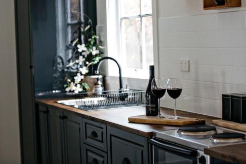 a kitchen with two glasses of wine on a counter at Northfield Boutique Apartments in Woodend