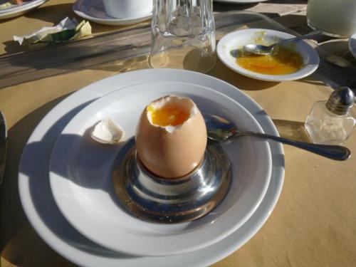 ein Ei auf einer weißen Platte auf einem Tisch in der Unterkunft La Locanda Di Cadì in Petralia Soprana