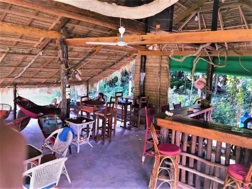 a restaurant with chairs and tables and a bar at Lazy Bones in Koh Rong Sanloem