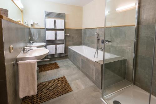 ein Badezimmer mit einer Dusche, einer Badewanne und einem Waschbecken in der Unterkunft Ferienappartements Landhof in Ellmau