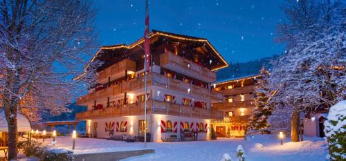 a large building in the snow at night at Ferienappartements Landhof in Ellmau