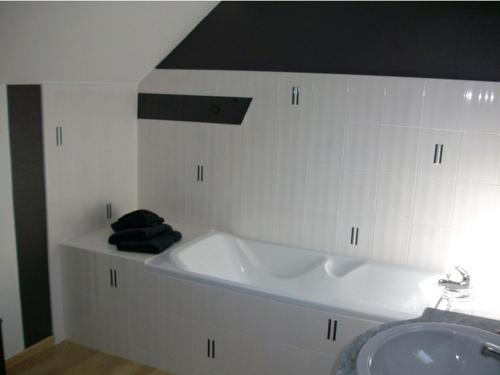 a bathroom with a bath tub and a sink at Le Grand Gîte in Dorengt