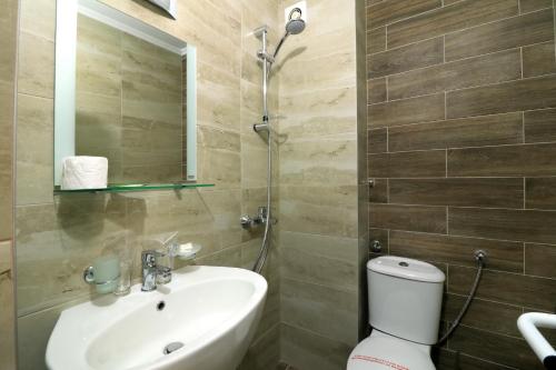 La salle de bains est pourvue d'un lavabo, de toilettes et d'un miroir. dans l'établissement Family Hotel Jupiter, à Balchik