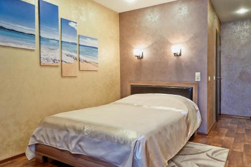 Schlafzimmer mit einem Bett und Wandmalereien in der Unterkunft Idillia Mini Hotel in Welikije Luki