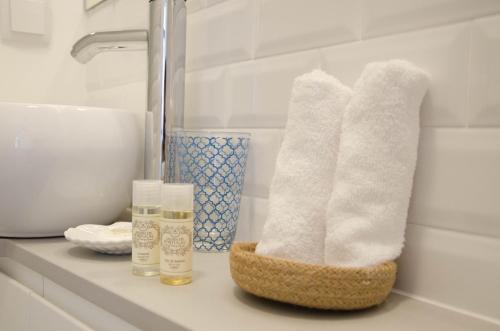 a bathroom with white towels on a counter with a sink at Porto Moments Apartments by Portugal Collection in Vila Nova de Gaia