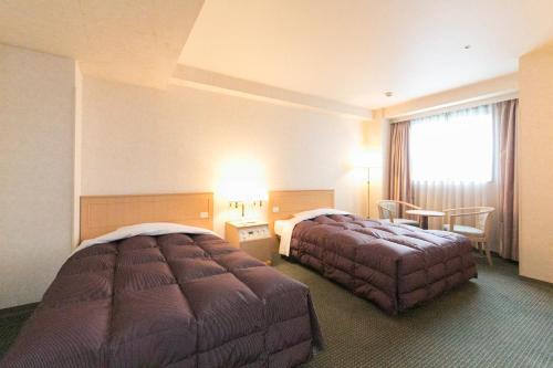 A bed or beds in a room at Hida Takayama Washington Hotel Plaza