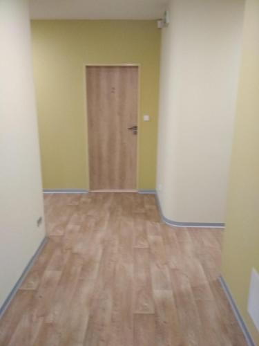 an empty room with a door and a wooden floor at Penzion Pod Kaštany Kvasice in Kvasice