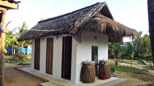 a small hut with a thatched roof and two poles at Lazy Bones in Koh Rong Sanloem