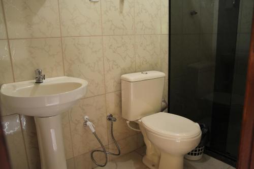 a bathroom with a toilet and a sink at Pousada Flor da Manhã in Sana