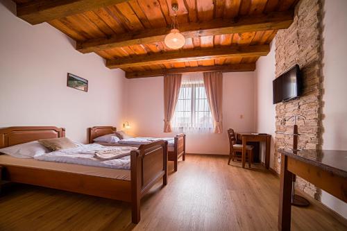 a bedroom with two beds and a stone wall at Hotel Tři Věžičky in Střítež