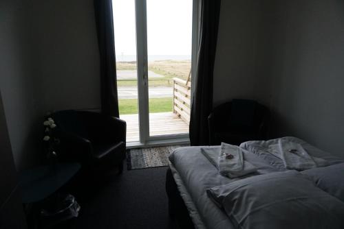 a bedroom with a bed and a window with a view at B&B by the Sea Hirtshals in Hirtshals