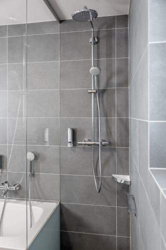 a bathroom with a shower with a tub and a shower head at Apartmenthaus Enzian Hochsölden in Sölden