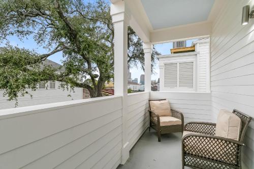 - une terrasse couverte avec 2 chaises et une fenêtre dans l'établissement Stunning 3BR on Carondelet by Hosteeva, à La Nouvelle-Orléans