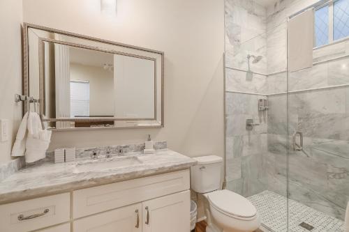 Un baño con inodoro, lavabo y ducha. en Hosteeva 3 BR Cottage Close to St Charles 5 m Ride to FQ, en Nueva Orleans