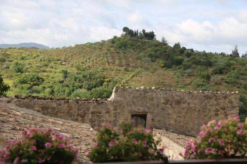 a stone building with a hill in the background at La Locanda Di Cadì in Petralia Soprana