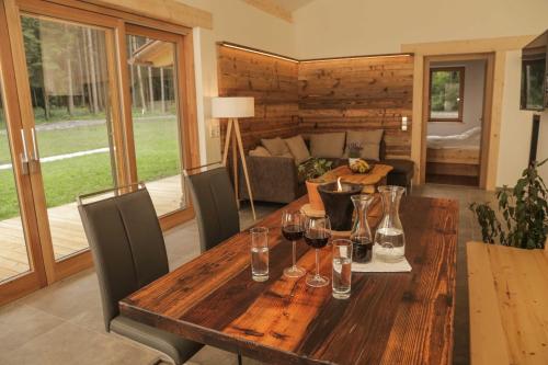 a wooden table in a living room with glasses of wine at Dobringers Chalet-Dorf Warös in Hermagor