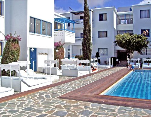 un hotel con piscina frente a un edificio en Tasmaria Aparthotel en Pafos