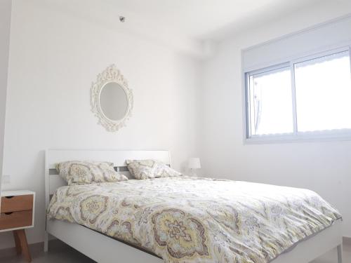 アシュドッドにあるShave Tsion Apartment in the center Ashdodの白いベッドルーム(ベッド1台、窓付)