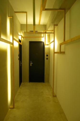 an empty hallway with a black door and lights at Just Inn Xin Yi 正旅館 信義 in Taipei