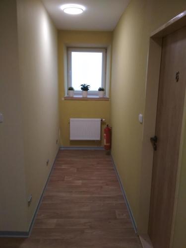 a hallway of an apartment with a window and a floor at Apartmány Pod Kaštany Kvasice in Kvasice