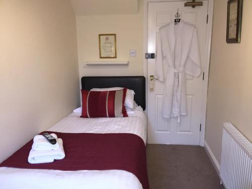 a bedroom with two beds and a robe hanging on the door at Clayhanger Guest House in Newcastle under Lyme