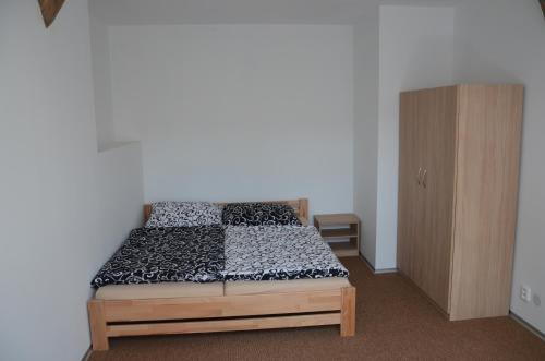 - une chambre avec un lit et une armoire en bois dans l'établissement Apartmány Pod Kaštany Kvasice, à Kvasice