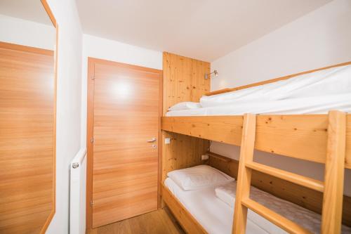 a bedroom with two bunk beds and a closet at Pichlerhof in Valle Di Casies